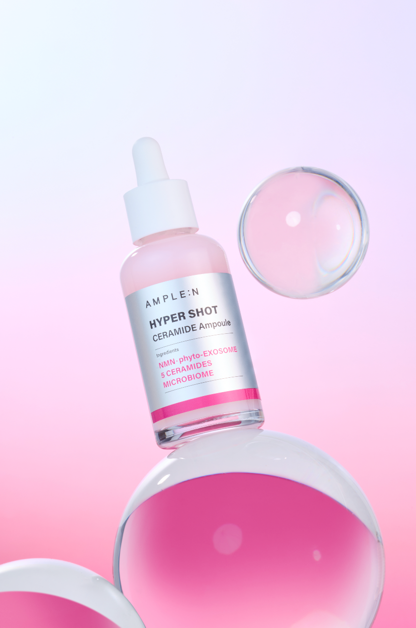Frasco AMPLEN Hyper Shot Ceramide Ampoule de 50 ml sobre fondo rosado.