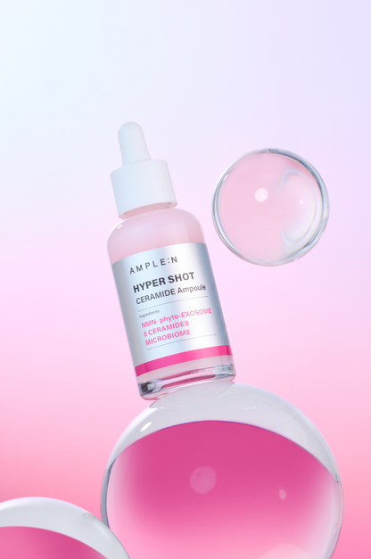 Frasco AMPLEN Hyper Shot Ceramide Ampoule de 50 ml sobre fondo rosado.