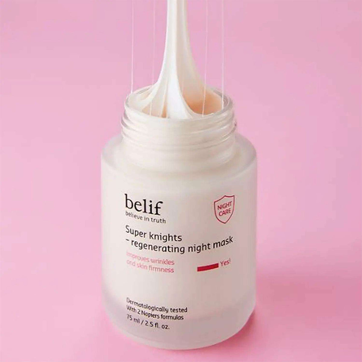 Tarro abierto de mascarilla Belif Super Knights con textura cremosa extendiéndose hacia arriba sobre fondo rosado.